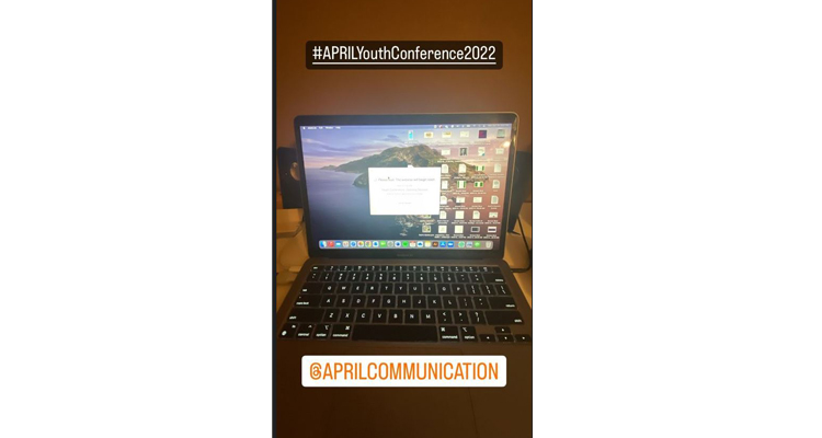 Screenshot of a computer that shows the conference schedule. Across the screen is the hashtag APRILYouthConference2022
