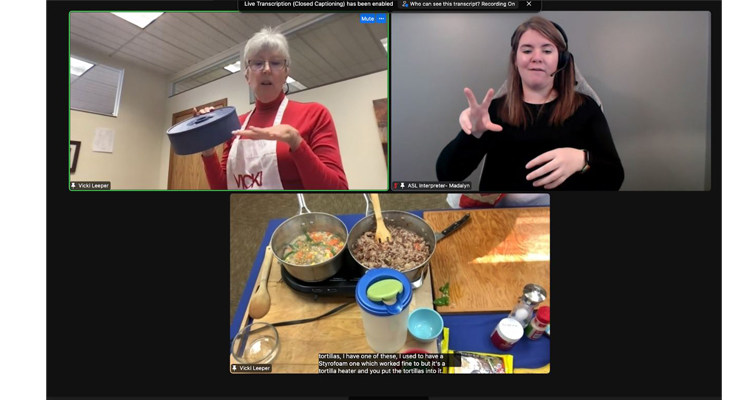 Screenshot of a live cooking demo session with Vicki Leeper. Vicki is a white woman with short white hair and glasses. Interpreter is a young woman with brown hair. Image of a burrito dish being cooked and prepared is shown at the bottom of the screen.