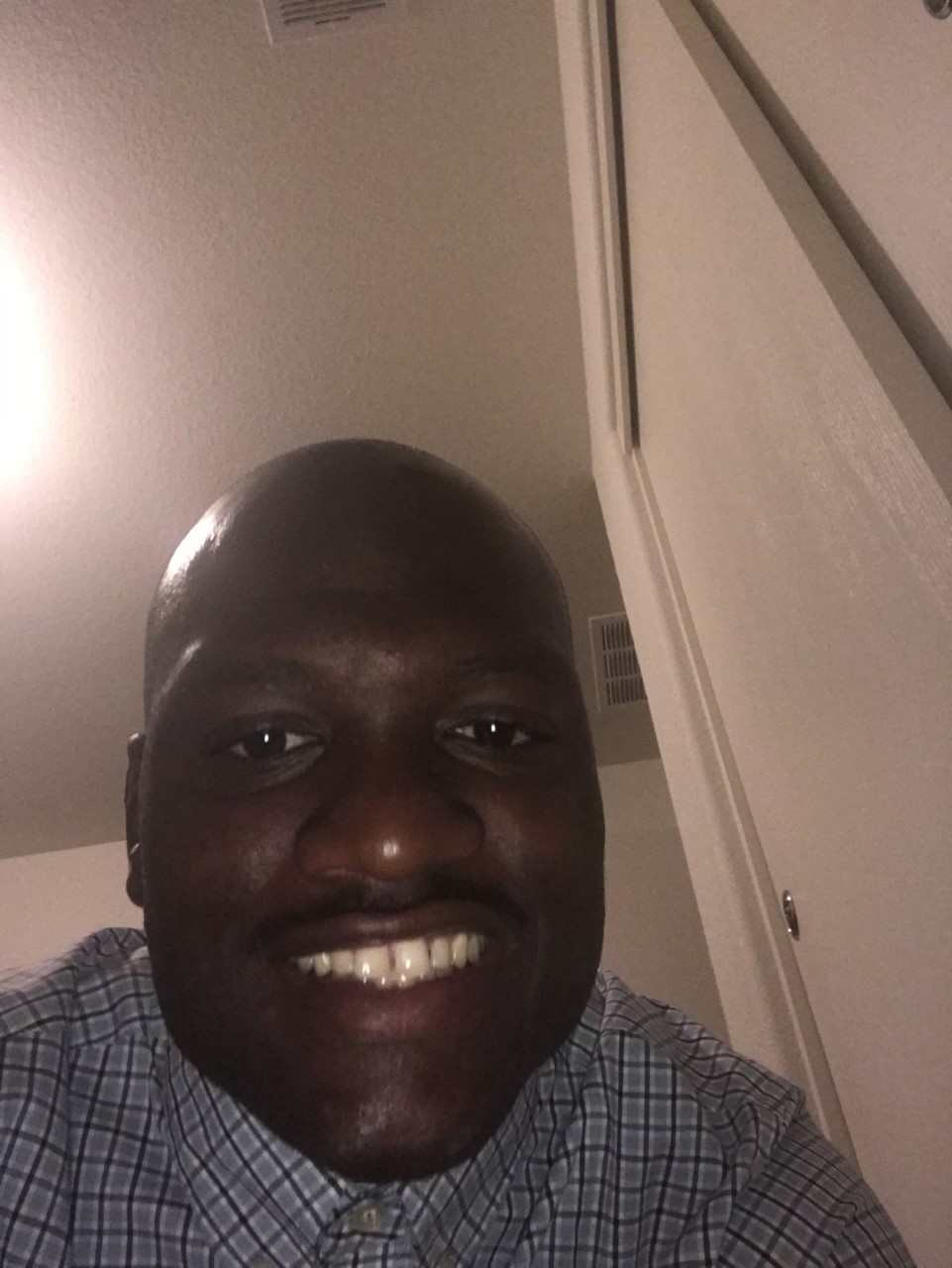 Selfie of Aerius, a Black man with a close cut buzz cut and wearing a button down shirt.