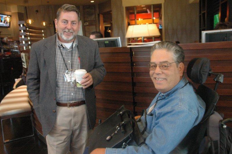 two men discussing conference with a cup of coffee