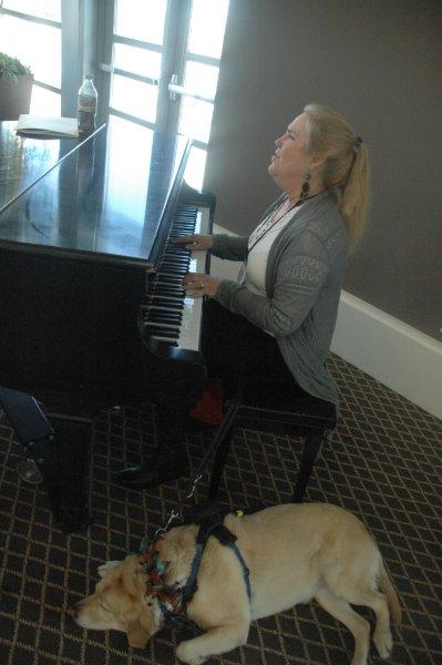 lady and guide dog playing a piano